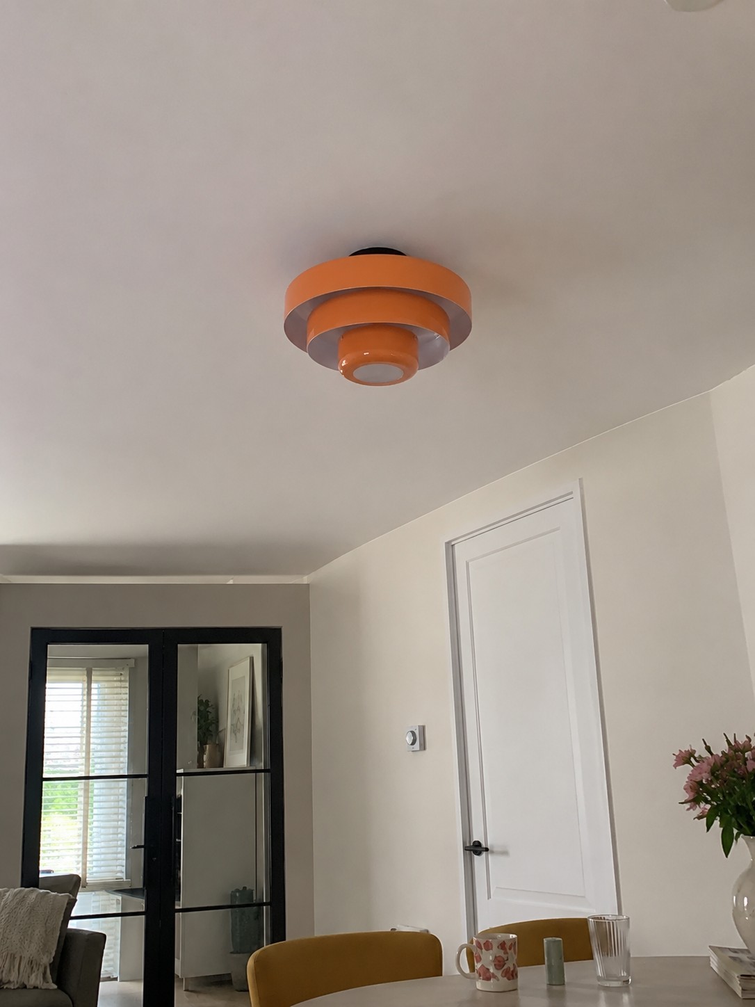Oranje Veleora plafondlamp in een lichte kamer