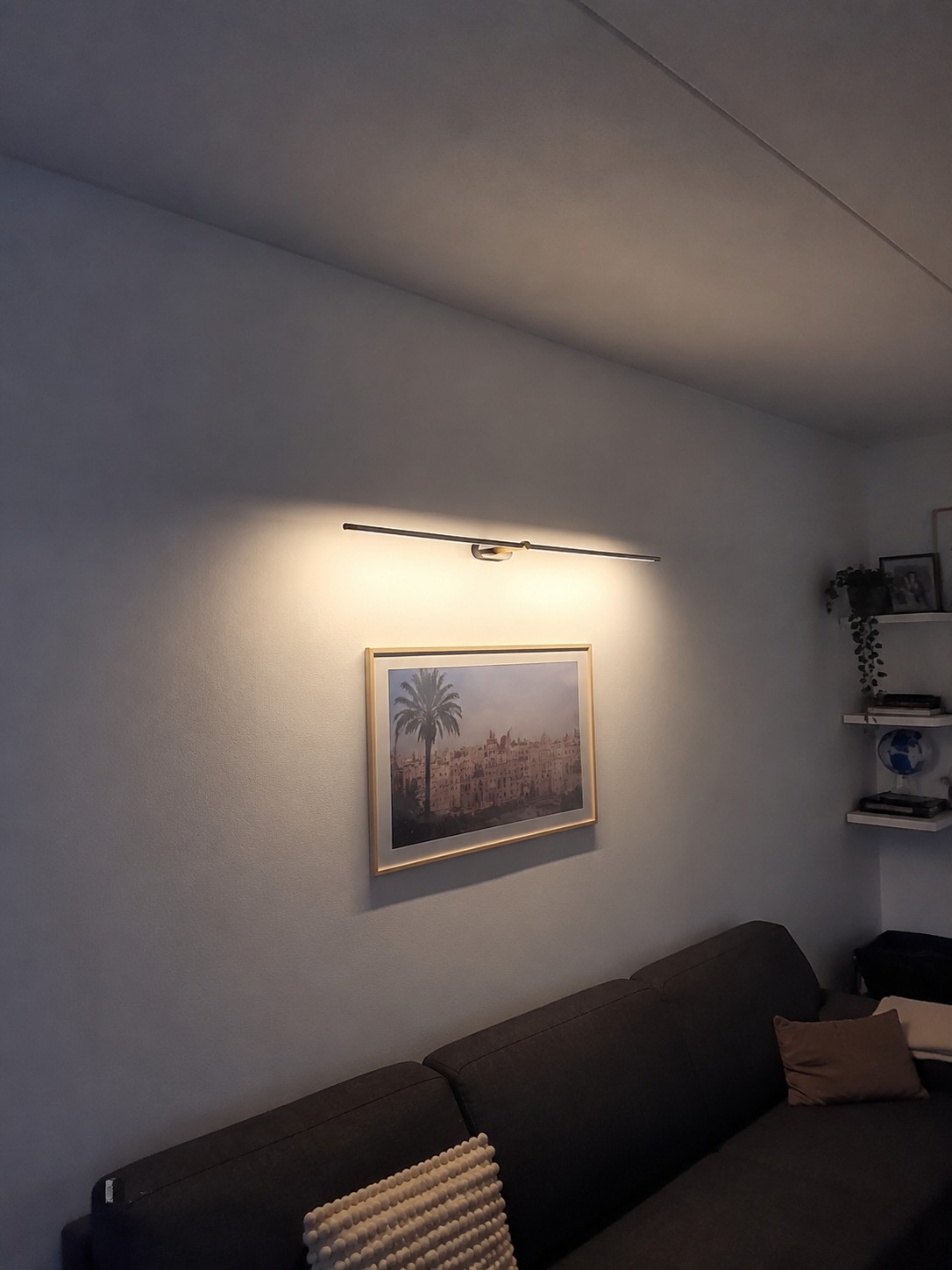 Kady wandlamp boven een bank in een woonruimte