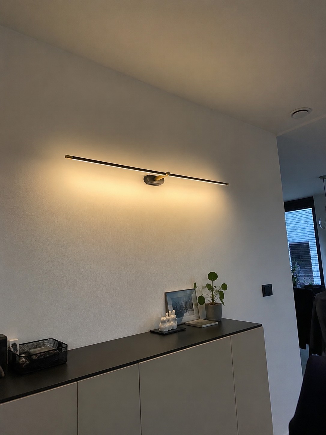 Kady wandlamp in een hal boven een dressoir