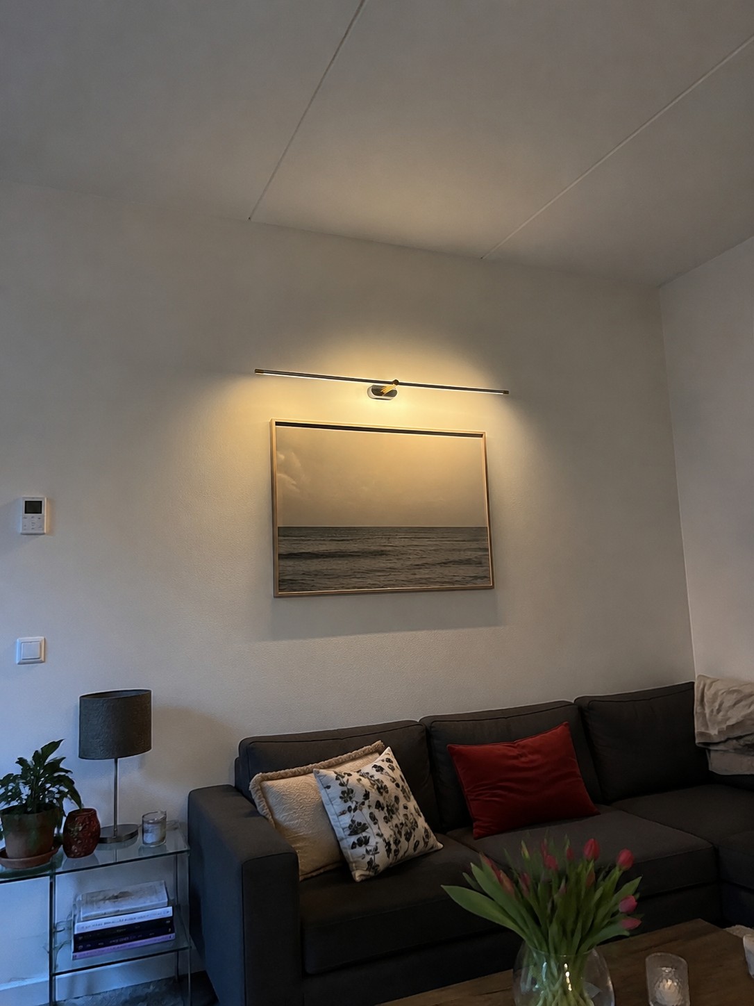 Kady wandlamp in een echt huis boven een bank