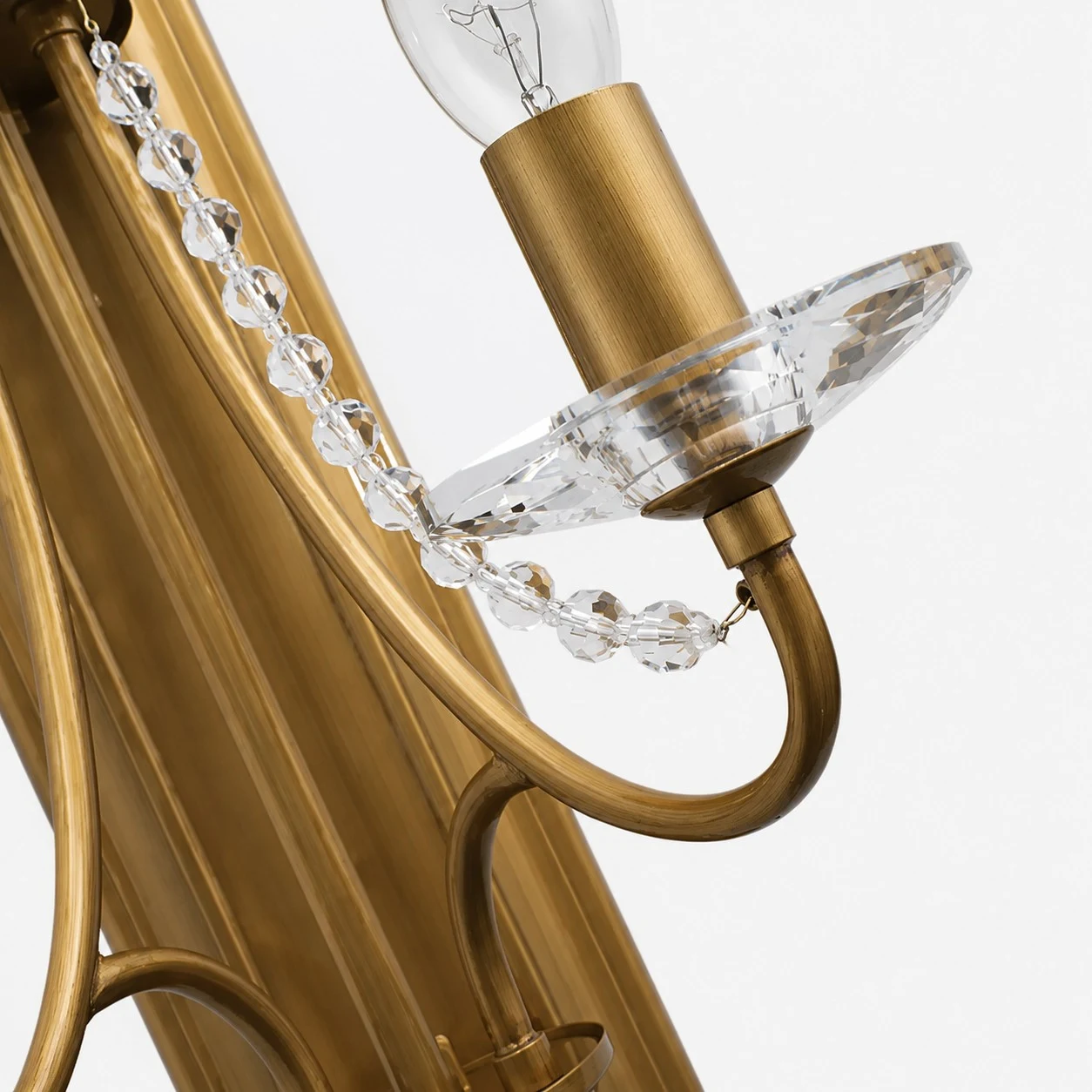 Close view of brass arm, candle cup and crystal chain detail