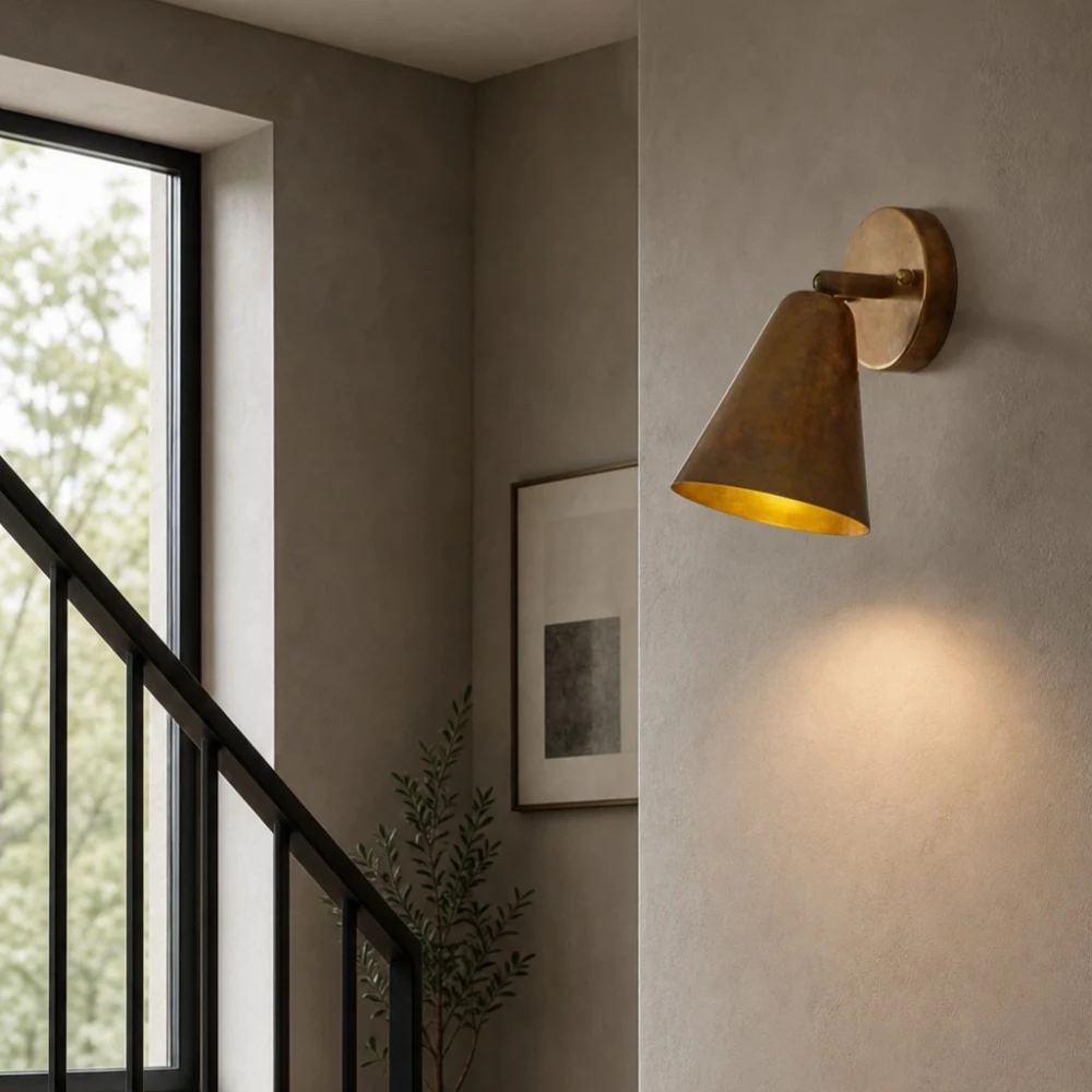Brass cone wall lamp beside stairway