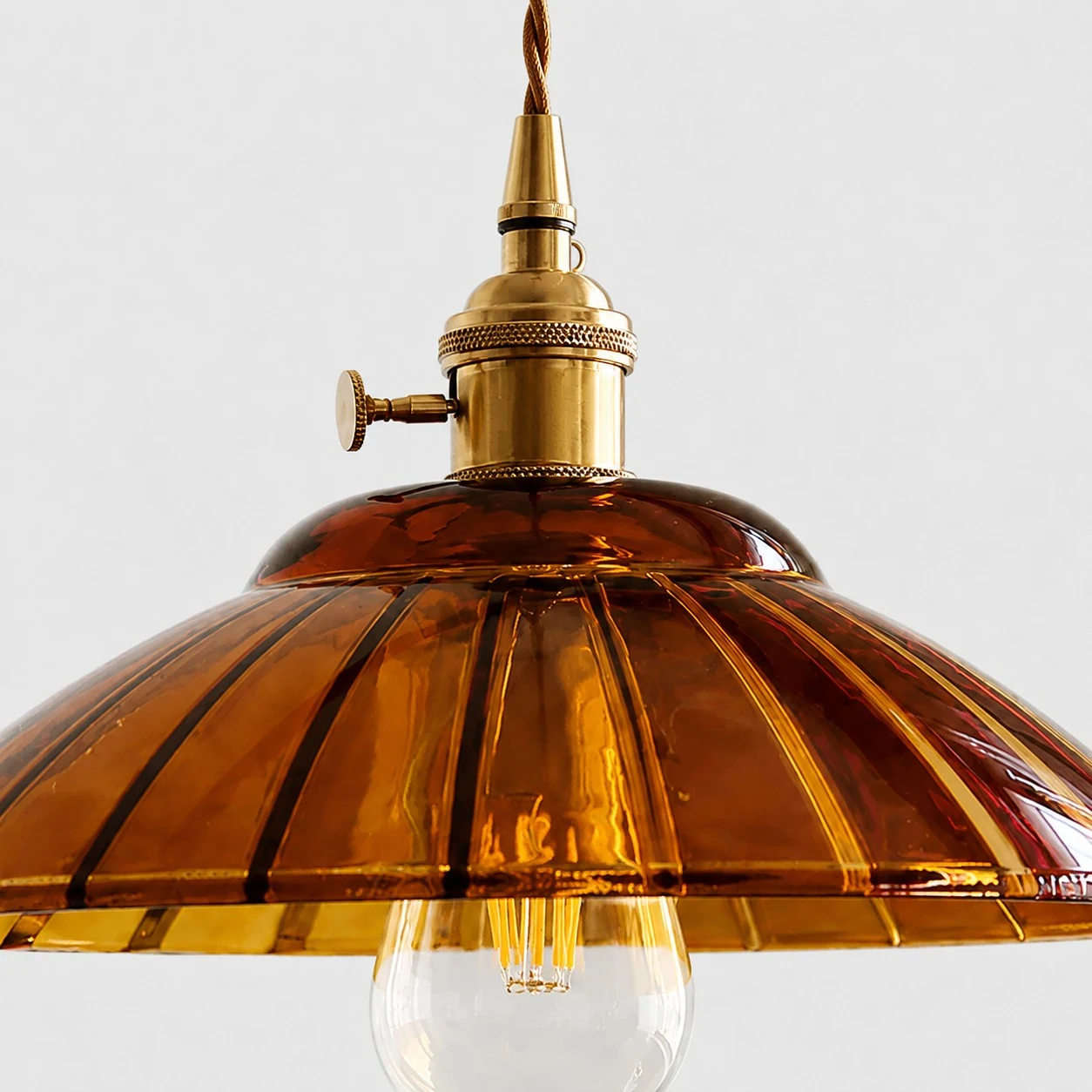 Amber ribbed glass shade and bulb detail