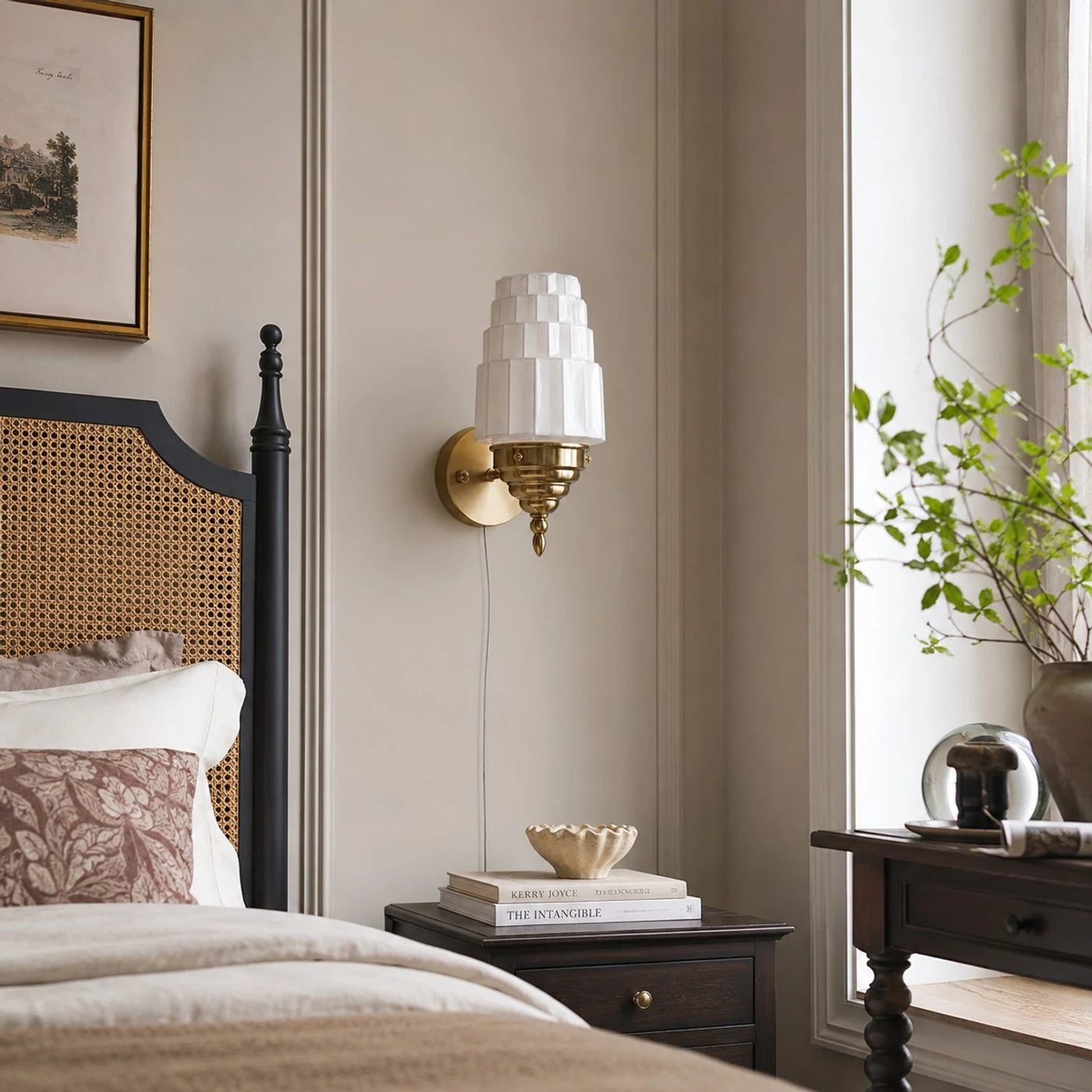 Antique brass Art Deco wall sconce beside a bed