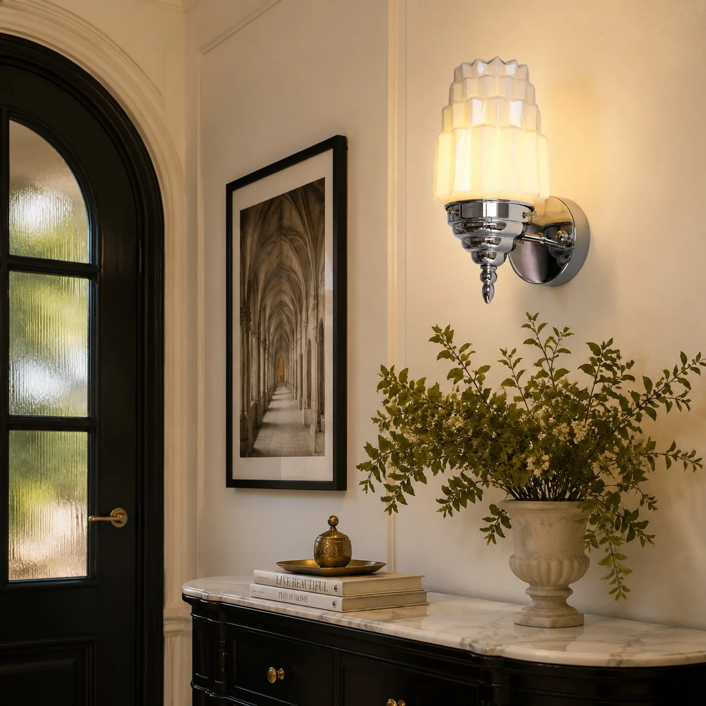 Chrome white glass wall sconce above an entry console