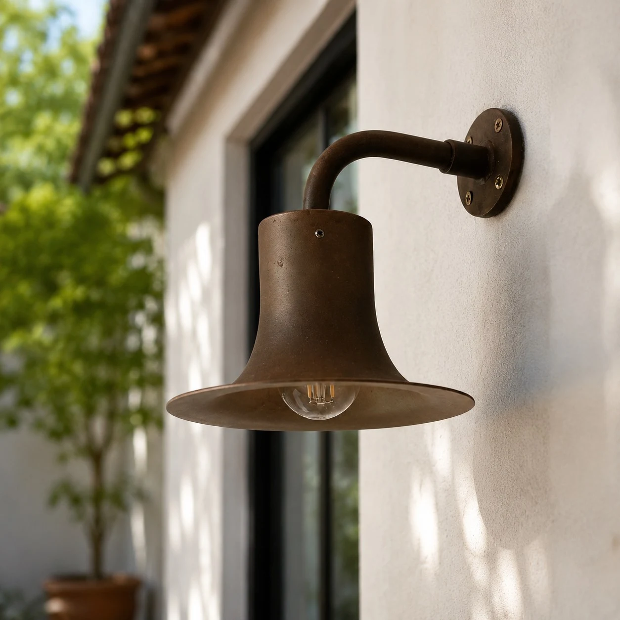 Antique brass wall sconce installed on an exterior wall in daylight