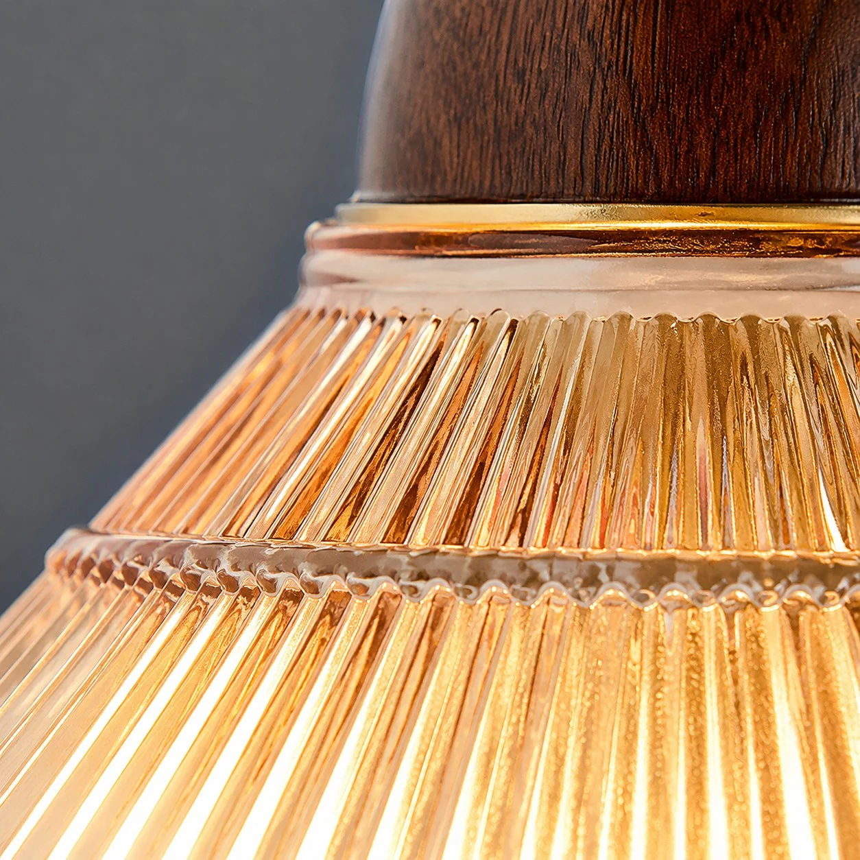 Close view of amber pleated shade and wood tone collar