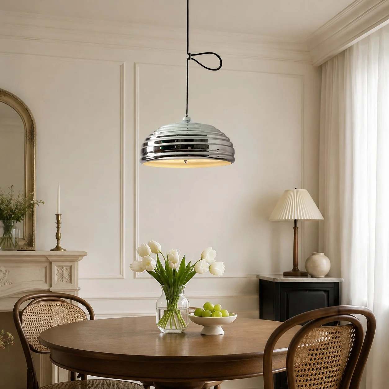 Adjustable chrome pendant light installed over a round dining table