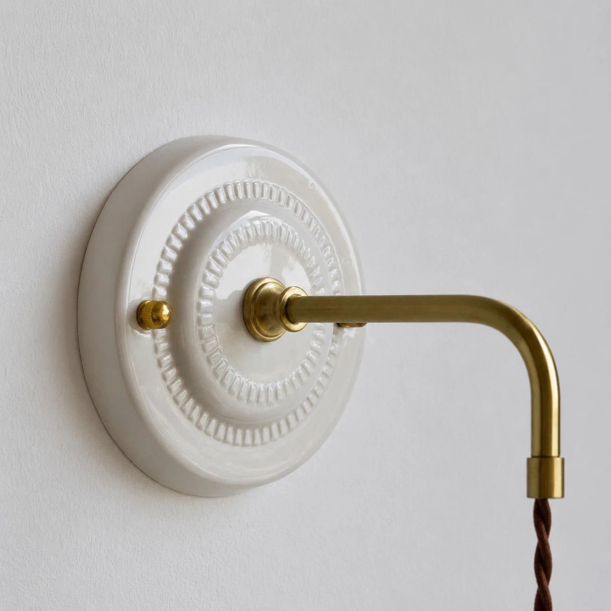 ceramic wall plate and brass arm detail