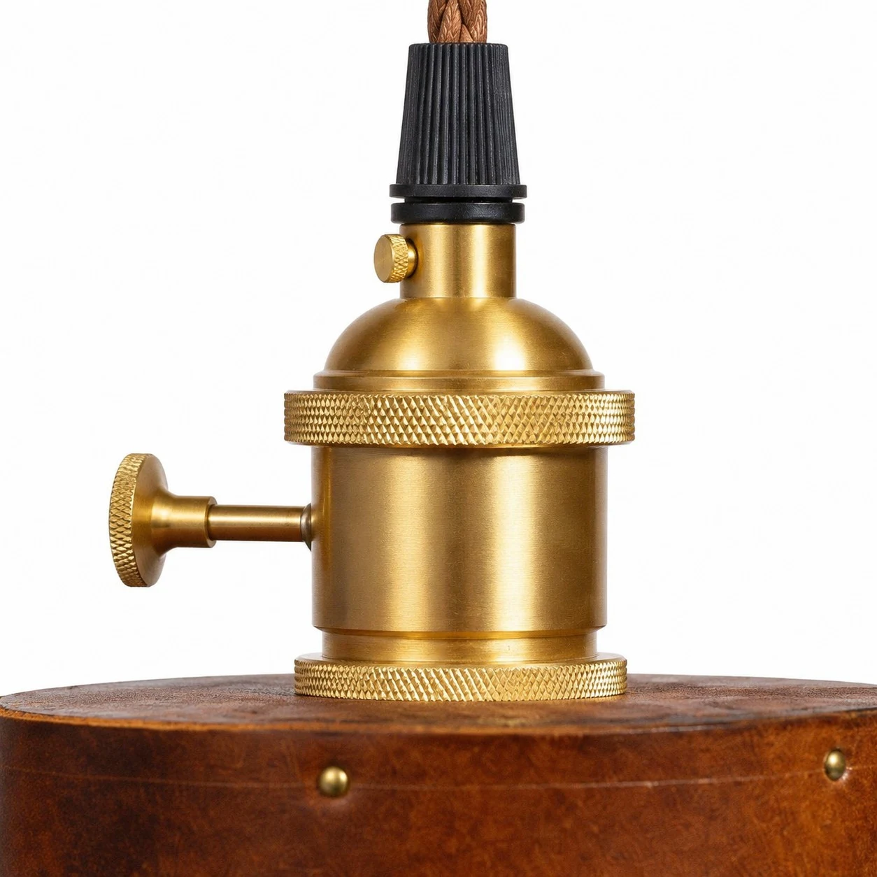 Close-up of brass socket on brown leather pendant lamp