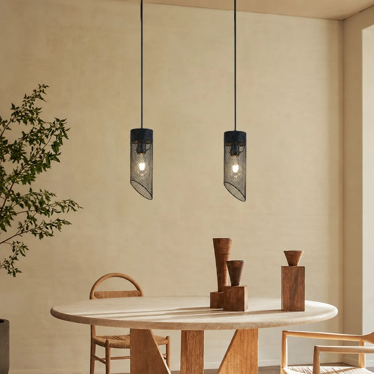 Black mesh stone pendant light installed above a round dining table