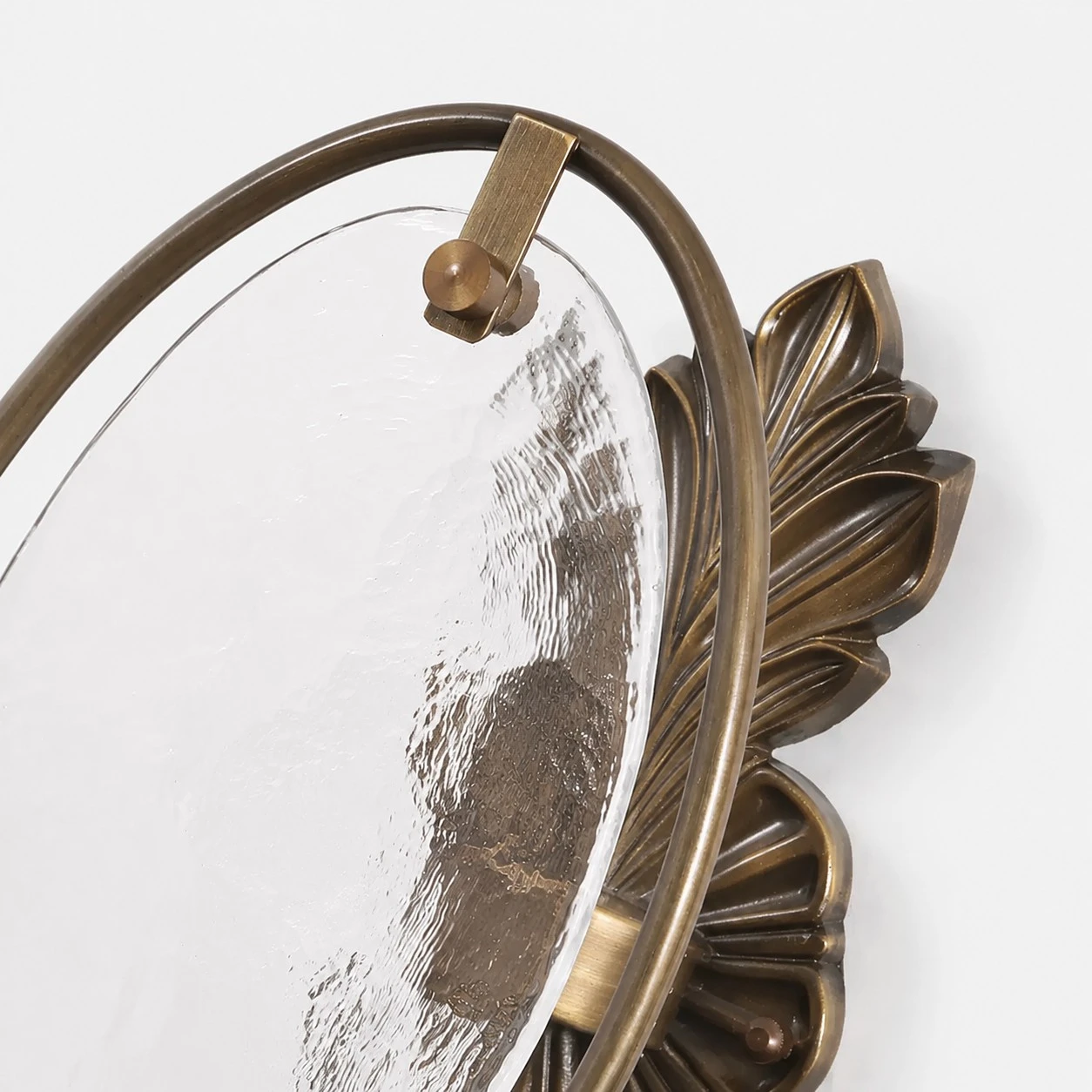 Close view of oval textured glass and antique brass frame detail