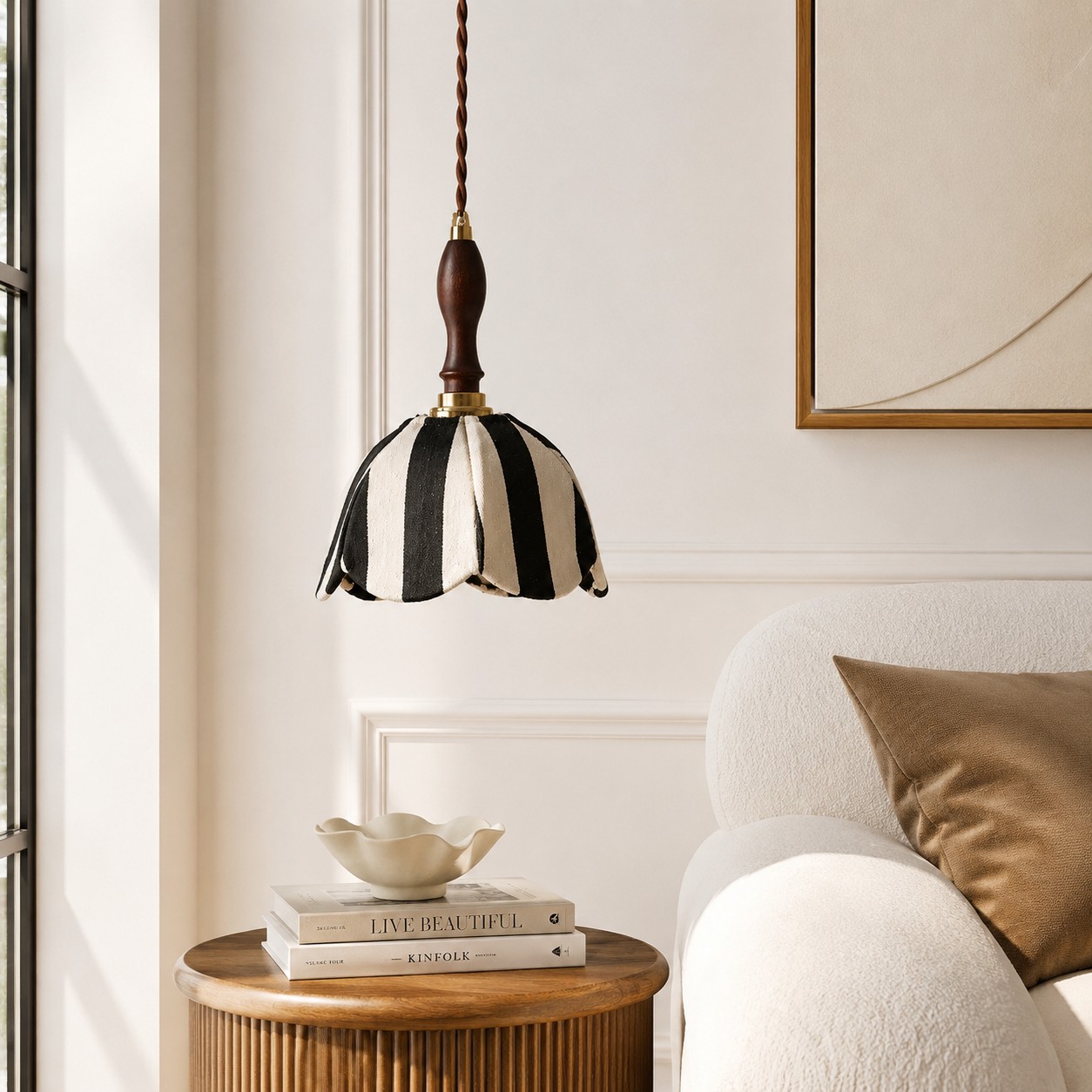 Black and ivory fabric pendant lamp above a side table beside a lounge chair