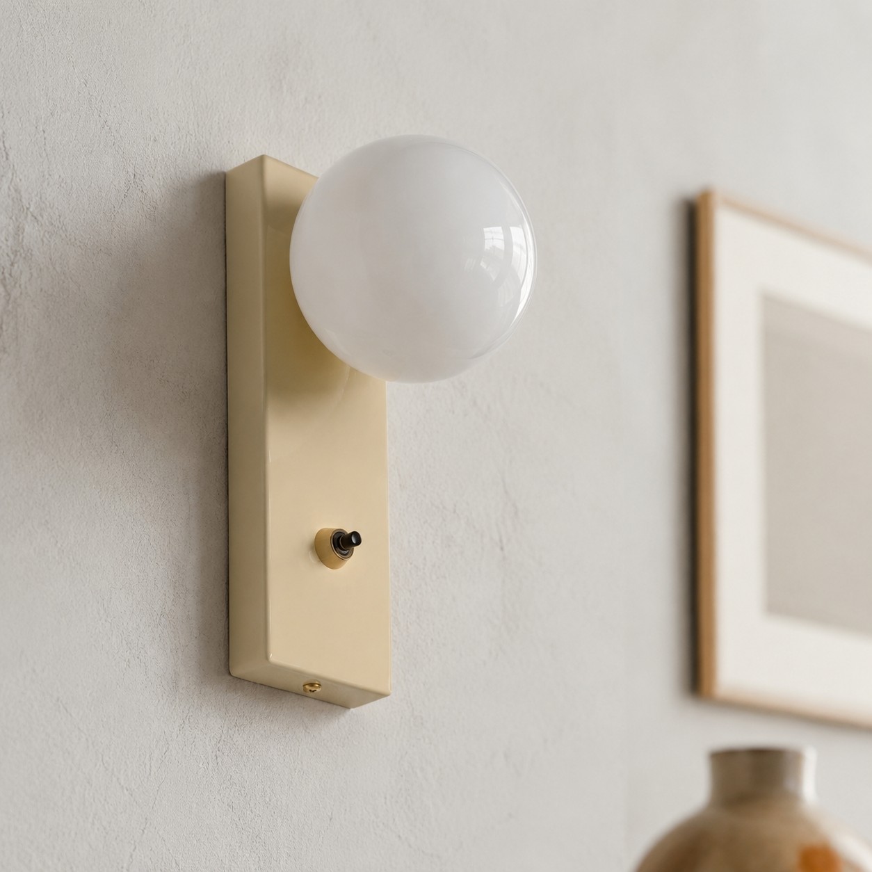 Close view of installed cream glass globe wall sconce