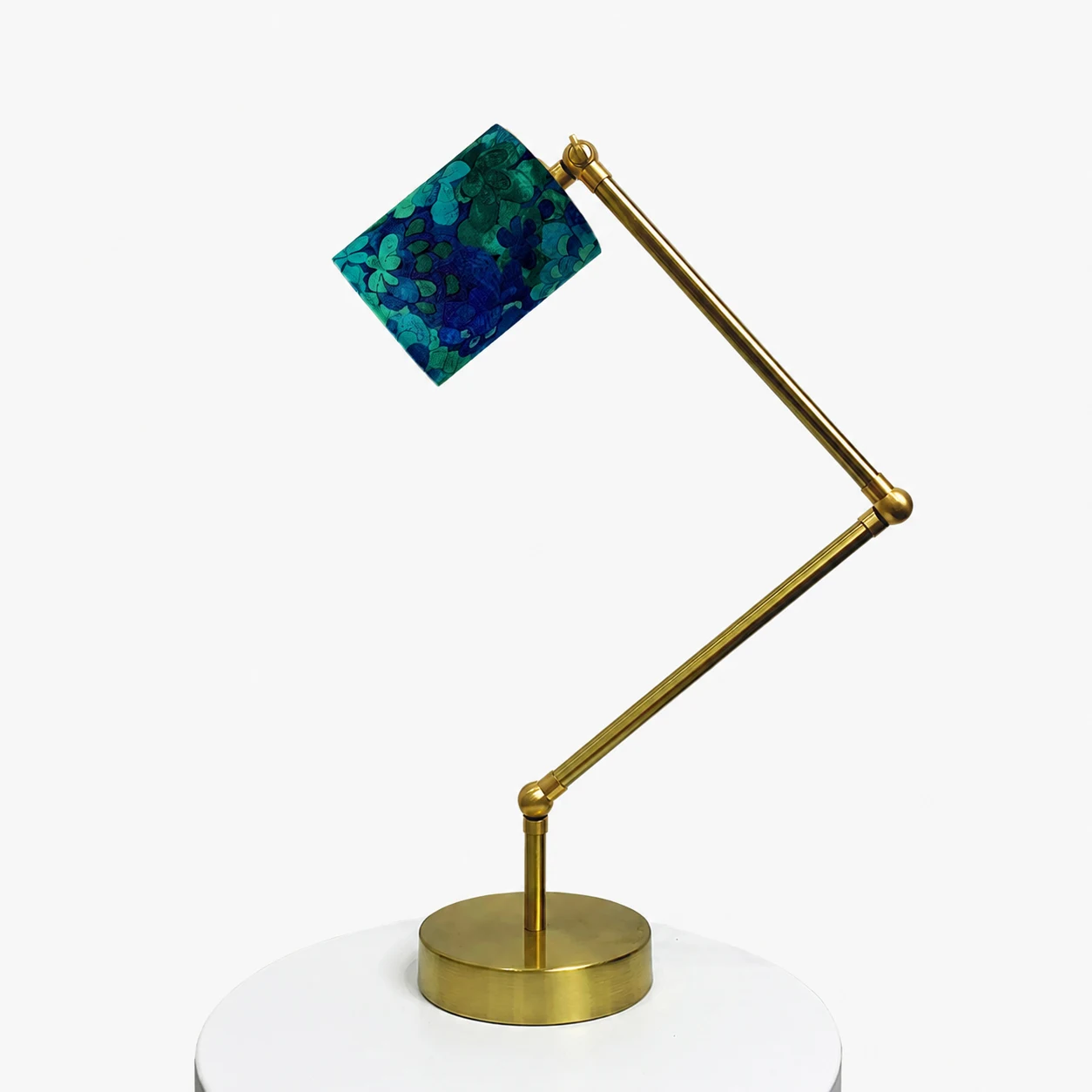 Adjustable brass-tone table lamp with blue green floral fabric shade