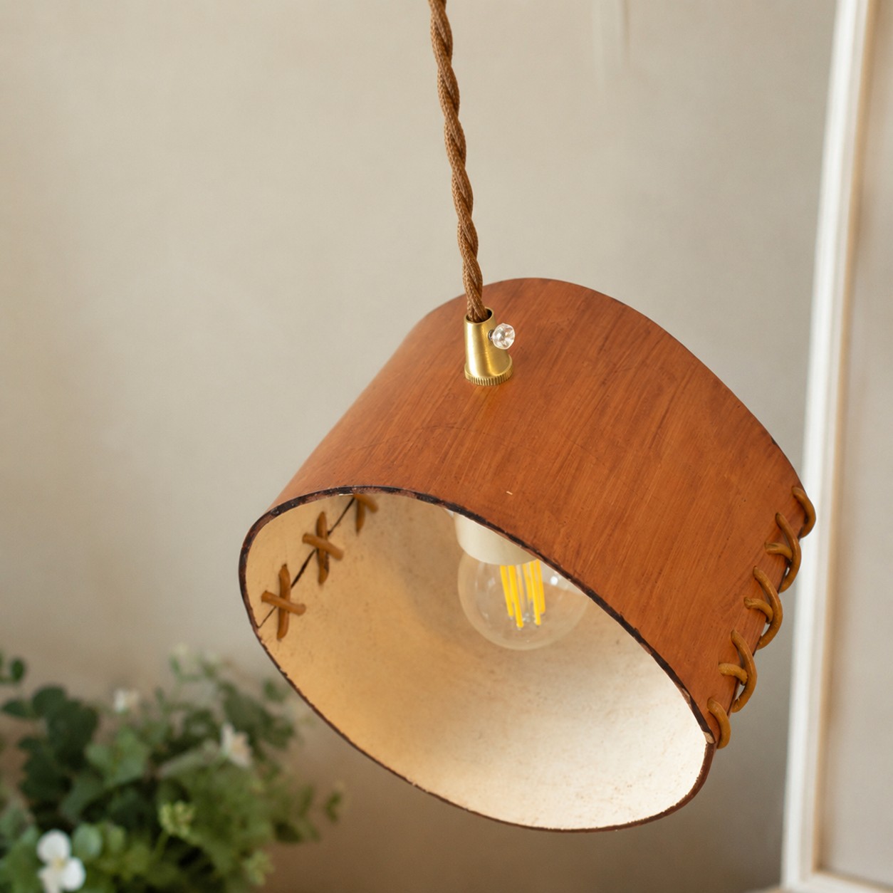 Open leather pendant shade with visible bulb and stitched edge