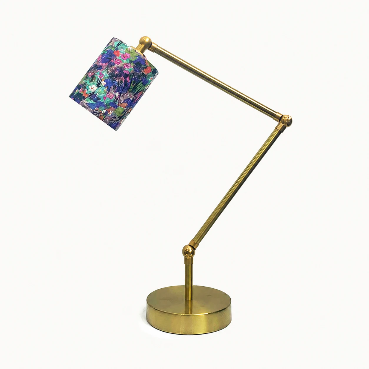Adjustable brass-tone table lamp with purple botanical fabric shade