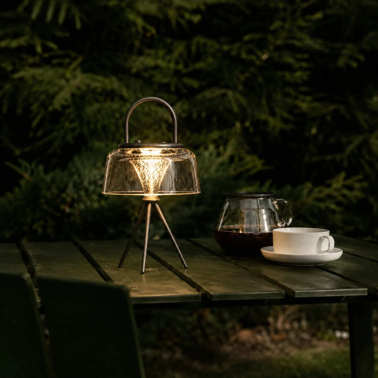 Solar garden lantern glowing on an outdoor table at night