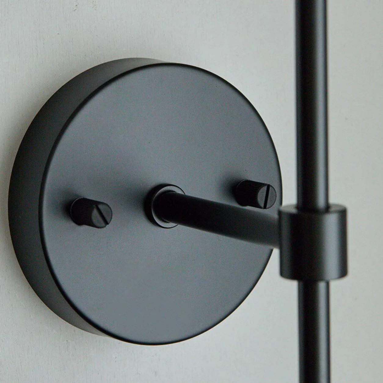 round black wall plate and lamp arm detail