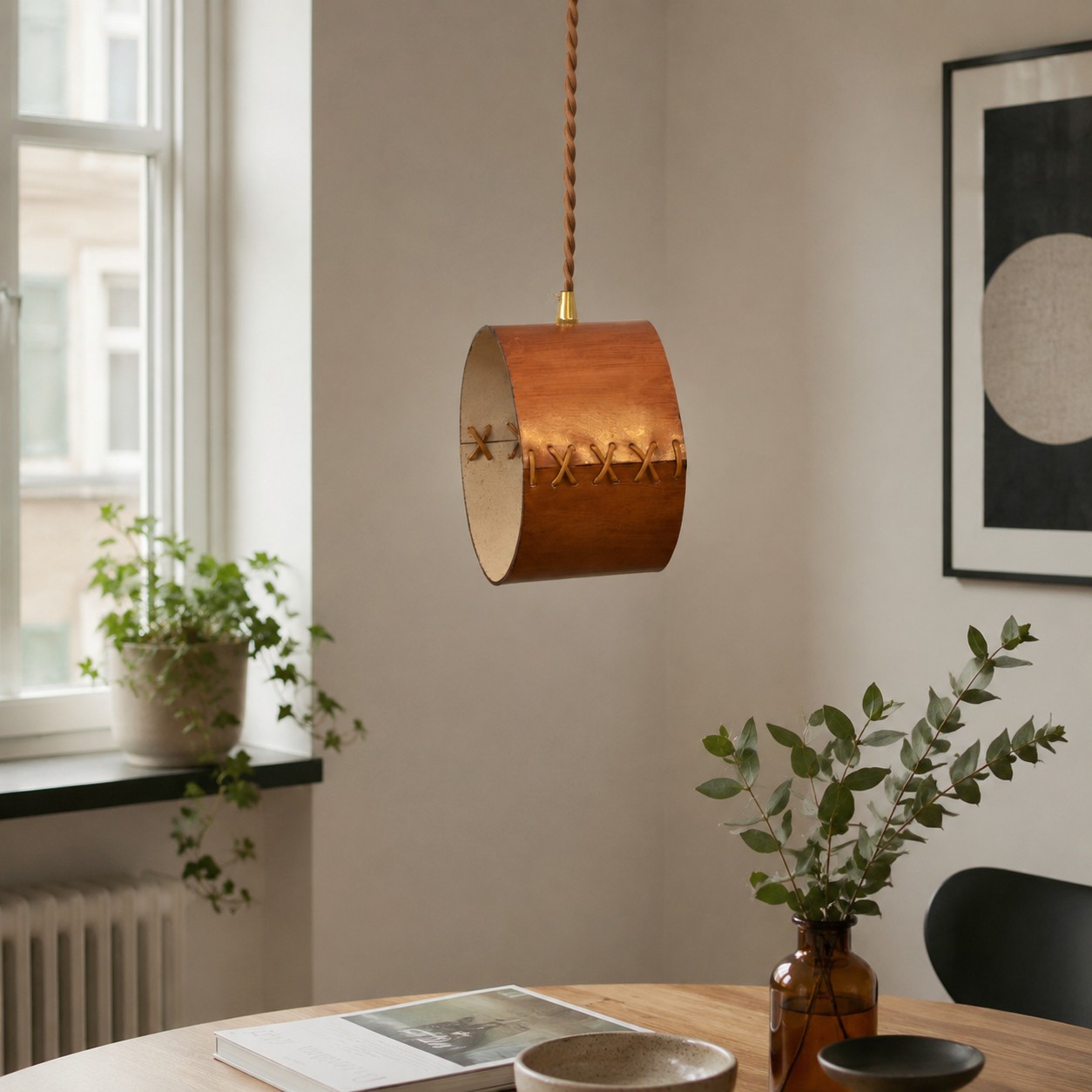 Hand-laced leather cylinder pendant light in an interior setting