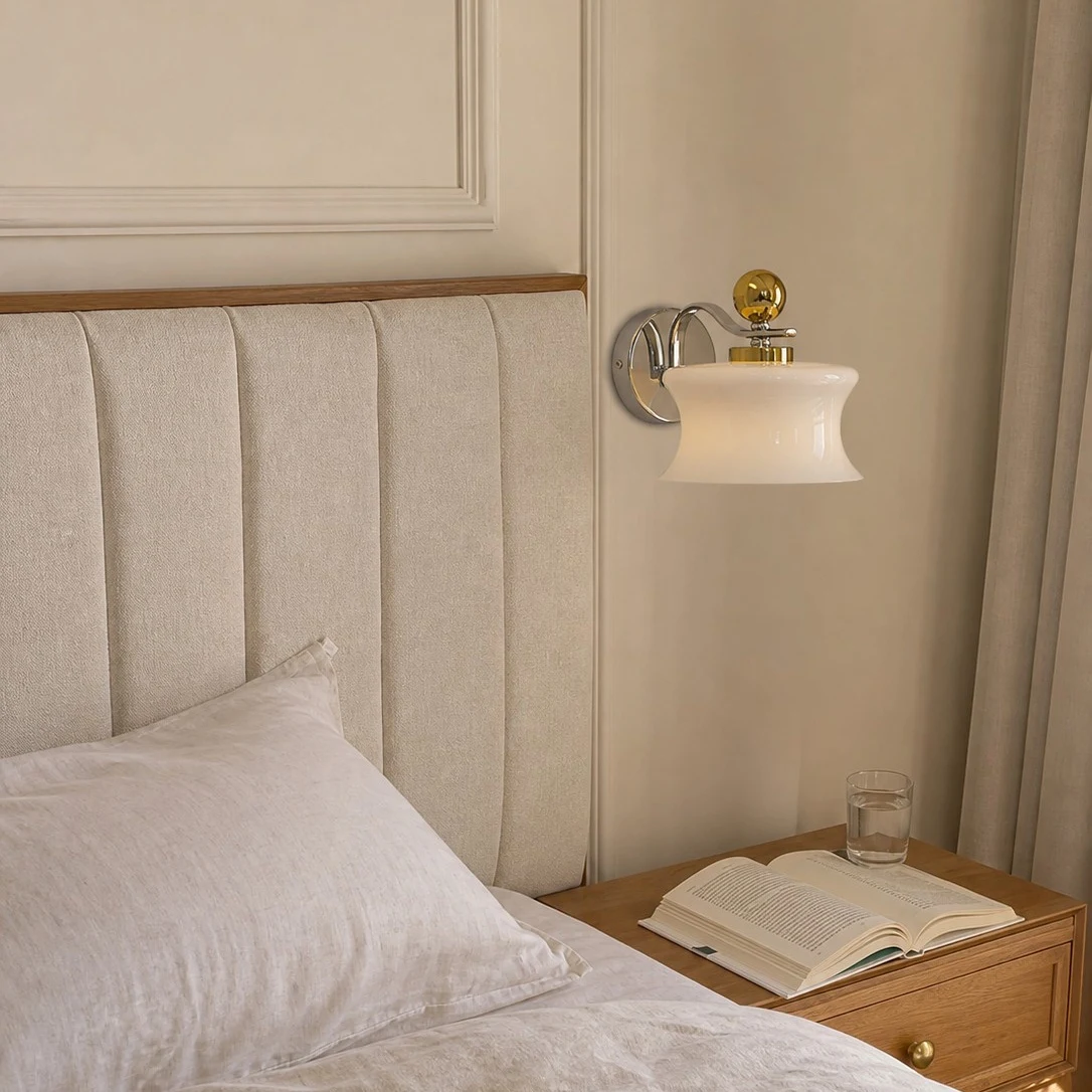 Cream glass wall lamp installed beside a bed