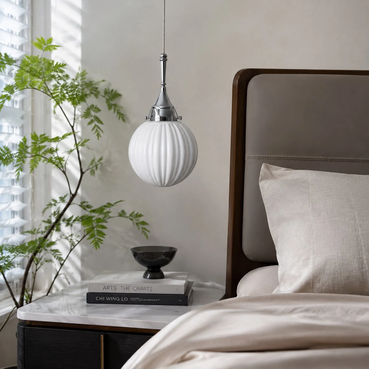 Ribbed glass pendant styled beside a bed