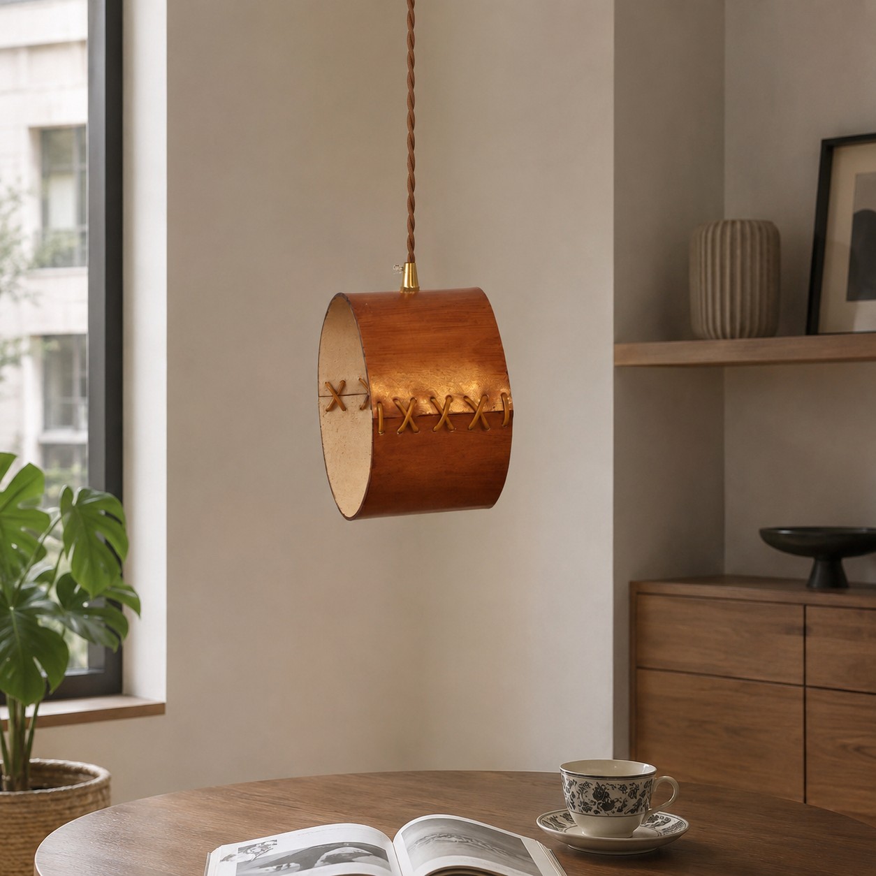 Hand-laced leather cylinder pendant light in an interior setting