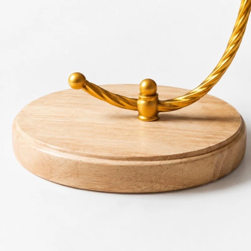 Close detail of the round wood base and twisted gold support