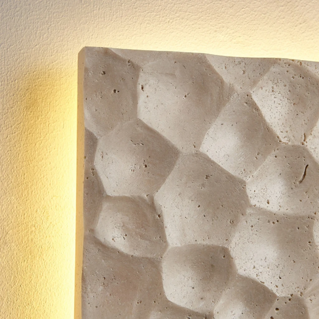 Side depth and hand-finished stone profile of the travertine wall sconce