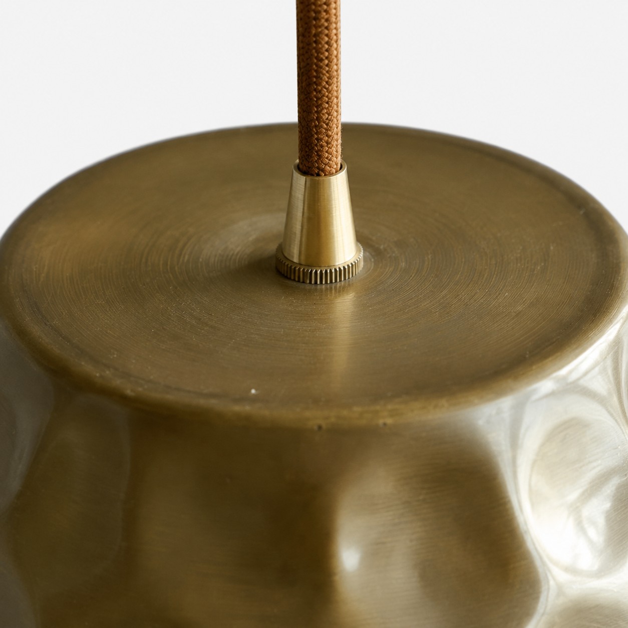 Close-up of the pendant cord connector and brushed brass top