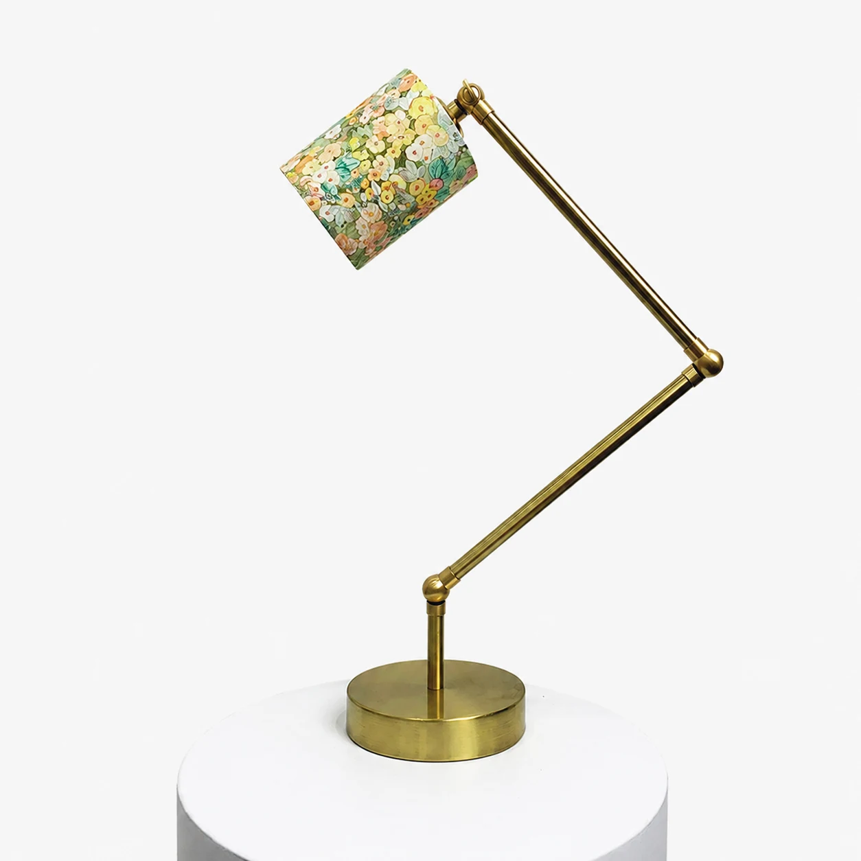 Adjustable brass-tone table lamp with cream garden floral fabric shade