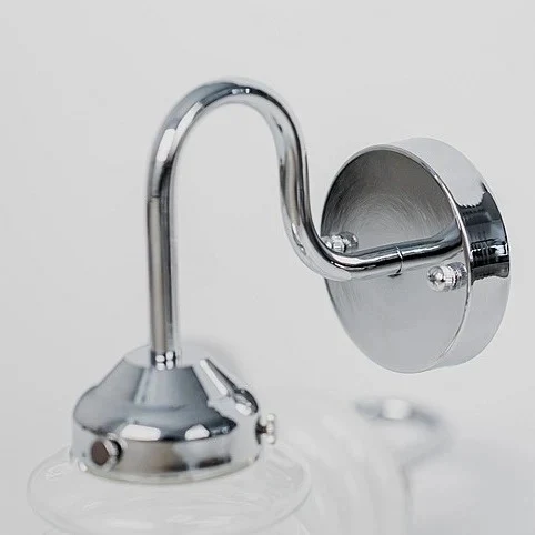 Curved chrome arm and round wall plate detail