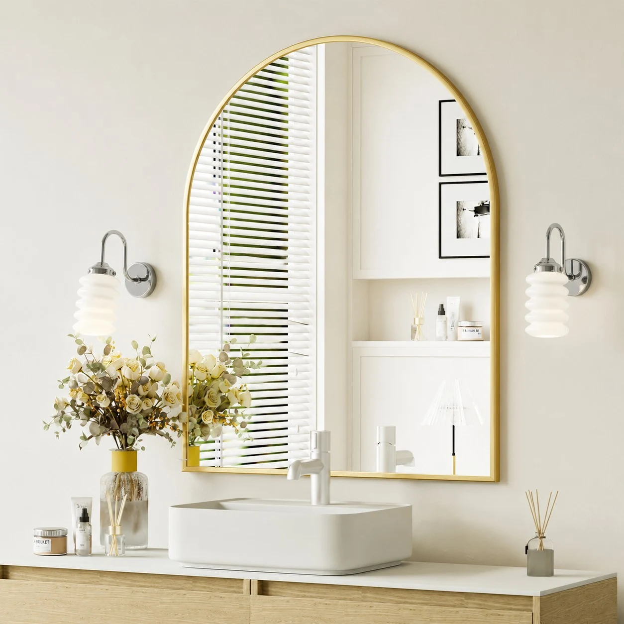 Chrome wall sconces framing a bright arched vanity mirror