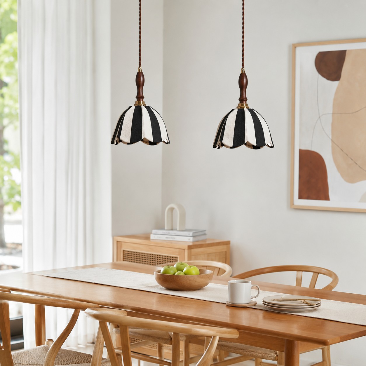 Pair of striped fabric pendant lamps above a wood dining table