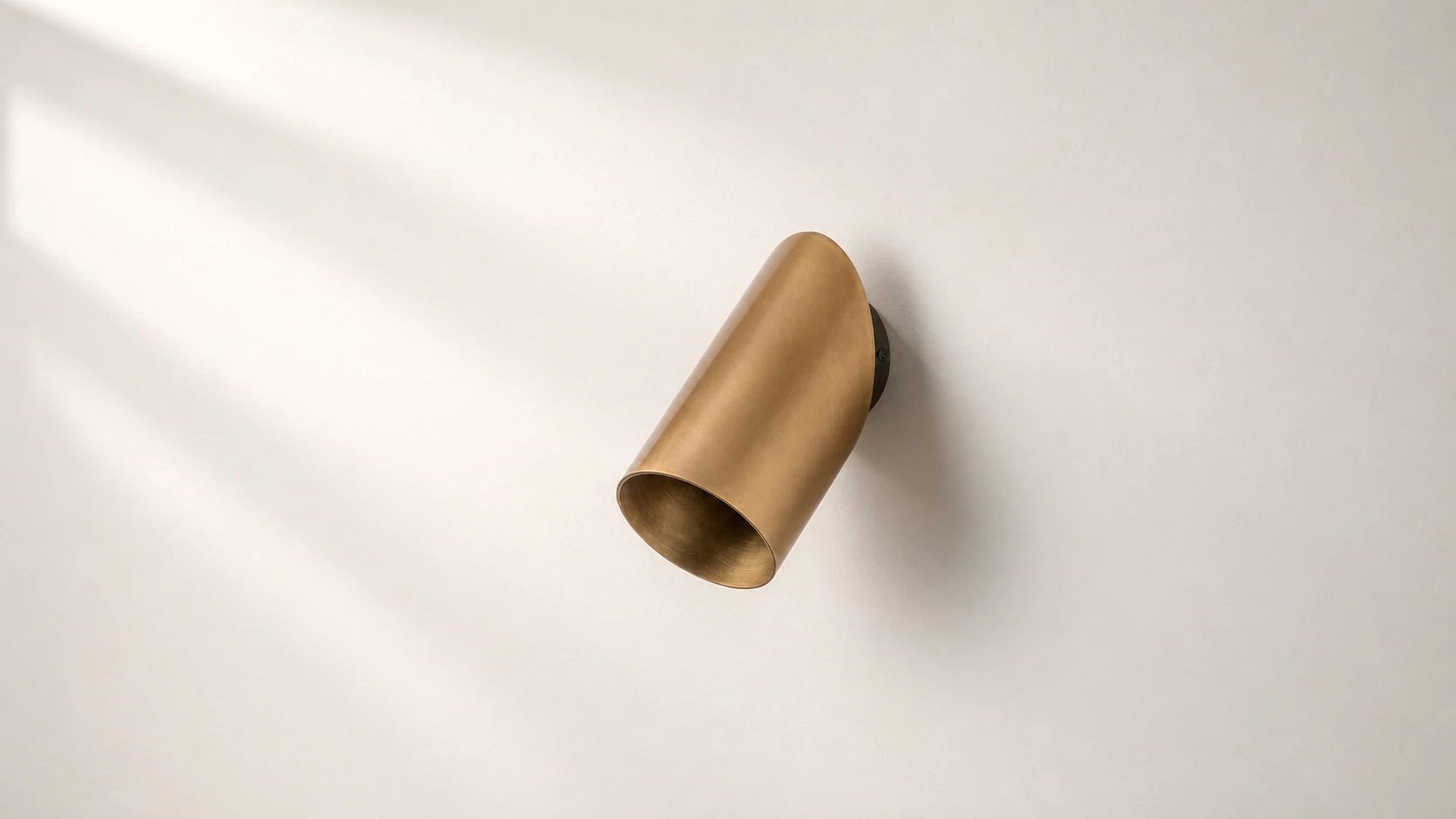 Guilla brass angled cylinder wall spotlight in a warm interior scene