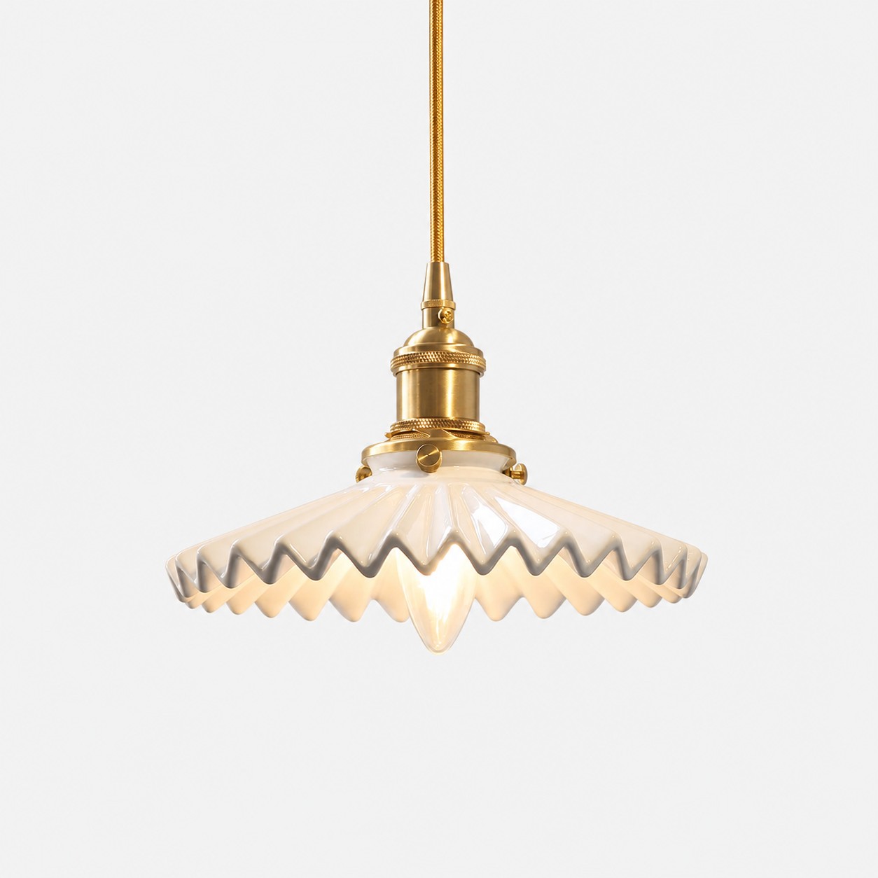 White pleated ceramic pendant light with brass-finish base